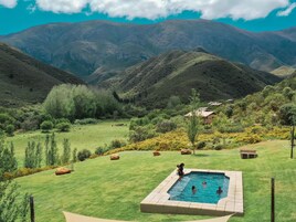 Una piscina al aire libre, sillones reclinables de piscina