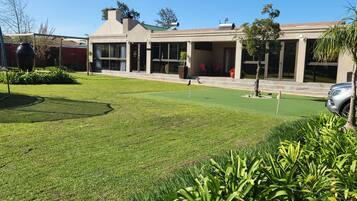 Guests can enjoy a well-manicured lawn with a putting green and a variety of plants.