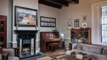 Una sala de estar tradicional con chimenea, un conjunto de sofás y una araña.