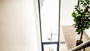 Una escalera con barandilla, una planta en maceta y un felpudo con la palabra 'Welcome'.