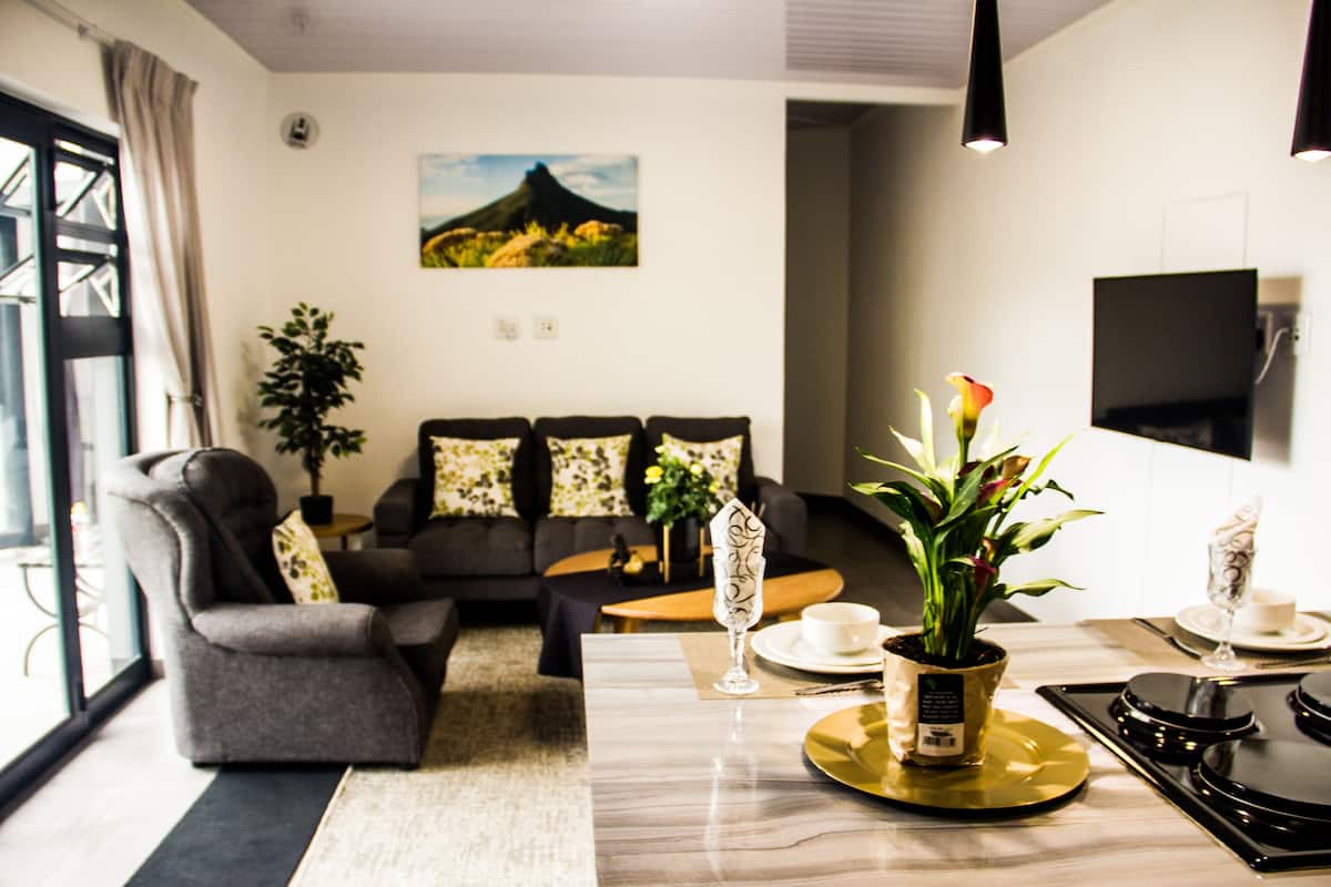 Deluxe appartement | Woonruimte | Een 64-inch smart-tv met kabelzenders en een televisie