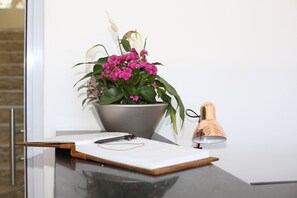 A desk with a potted plant, a pair of glasses, and a notebook. - The Noble Lodge (Cape Town)