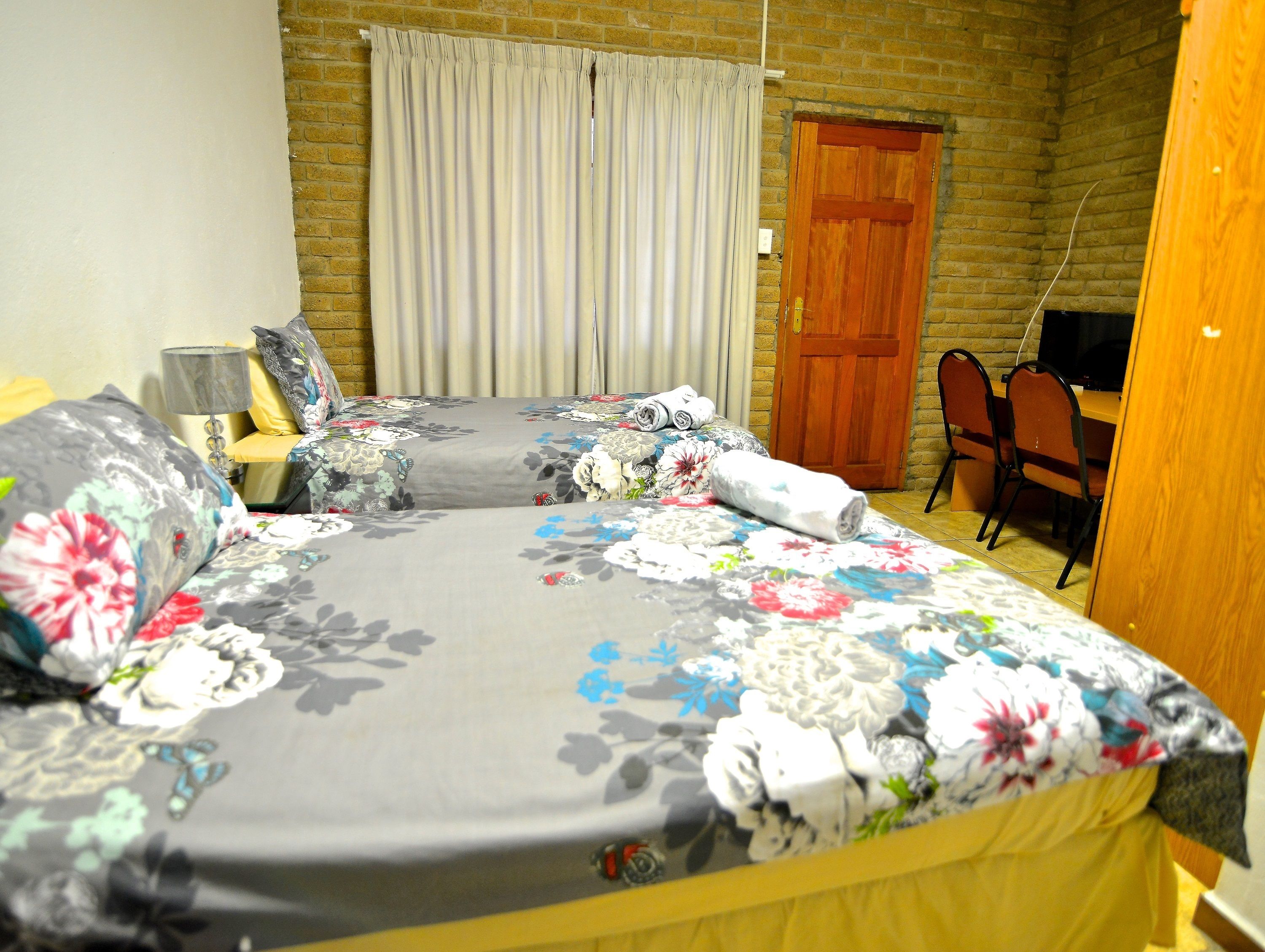 A bedroom with a bed, a desk, and a chair.