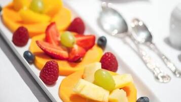 A white rectangular plate with fruit slices arranged in a row.