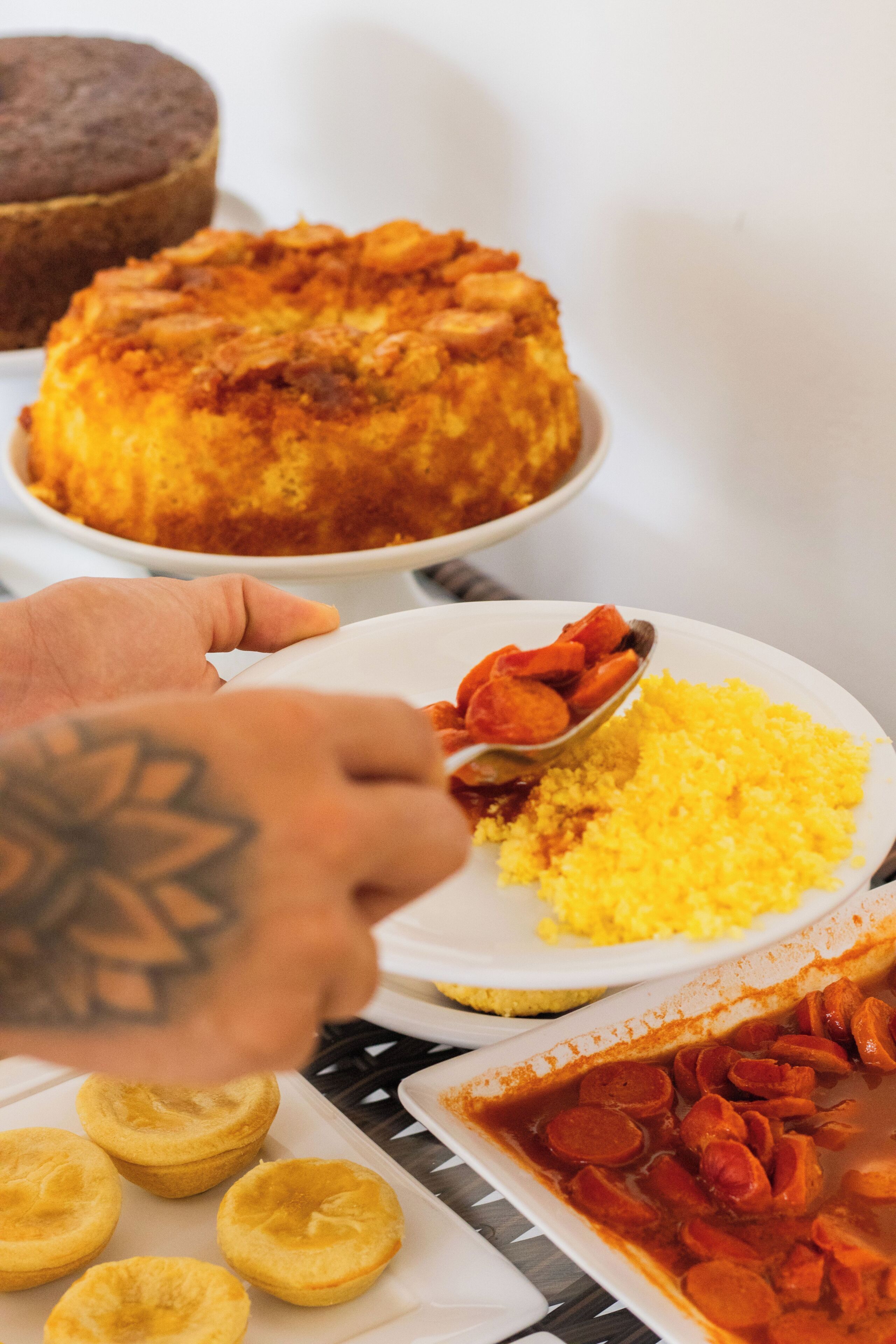 A person serving food from a white plate onto a white plate.