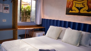 Une chambre à coucher avec un lit, des oreillers, un bureau et une fenêtre.