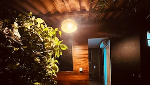 A wooden staircase leading to a room with a wooden ceiling and a hanging light fixture. - Pousada Boldro Home (Fernando de Noronha)