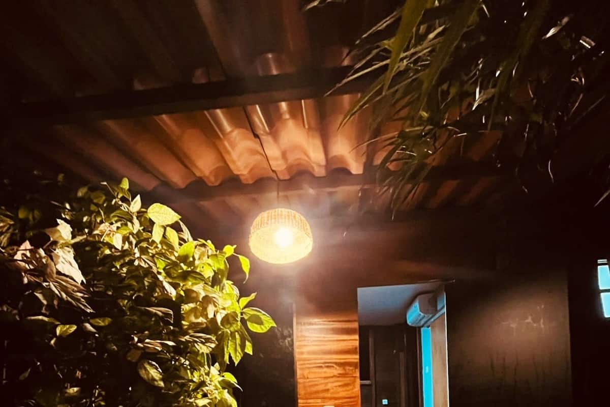 En trätrappa som leder upp till ett rum med ett träpanelat tak och en hängande lampa.