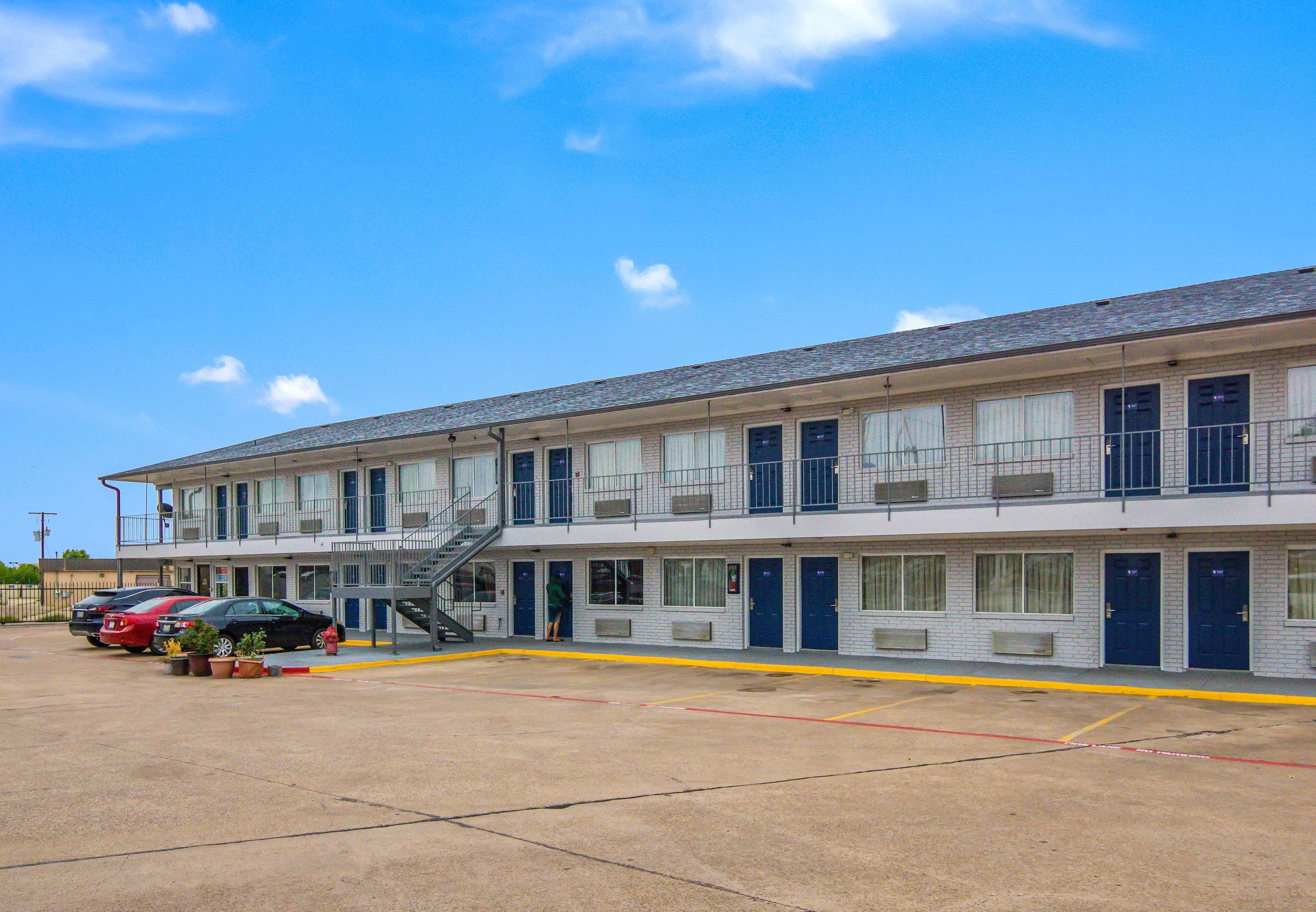 A motel with a two-story structure, multiple rooms, and a parking area.