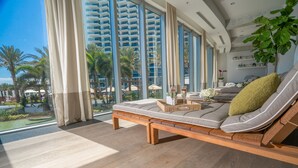 A modern living room with a large window, a sofa, and a coffee table. - Nobu Hotel Miami Beach (Miami Beach)
