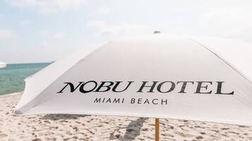 A beach umbrella with "Nobu Hotel Miami Beach" written on it.