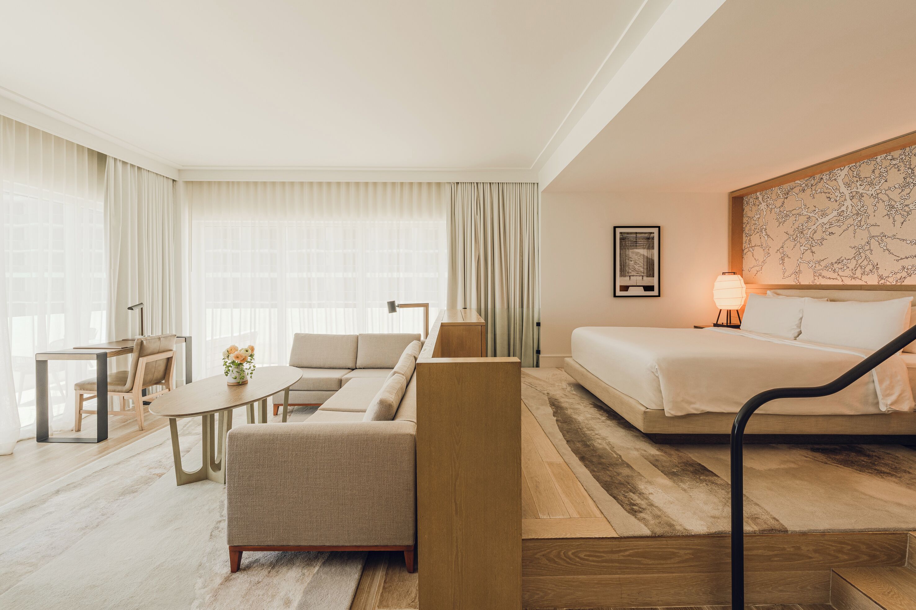 Ein Hotelzimmer mit einem Bett, einem Sofa, einem Esstisch und einem Sessel.