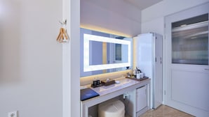 Ein modernes Badezimmer mit einem großen Spiegel, einem Waschbecken, einer Toilette und einem Mülleimer.