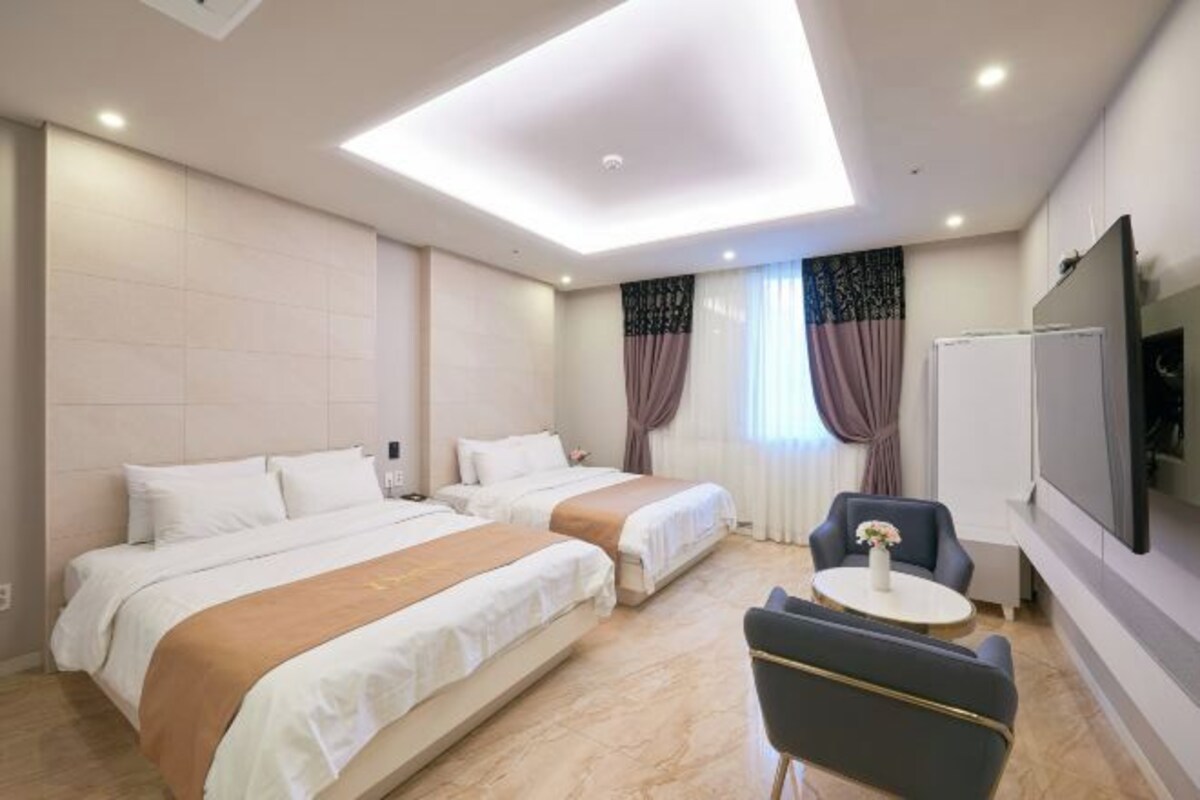 Une chambre d’hôtel avec deux lits, une télévision, une petite table et une chaise.