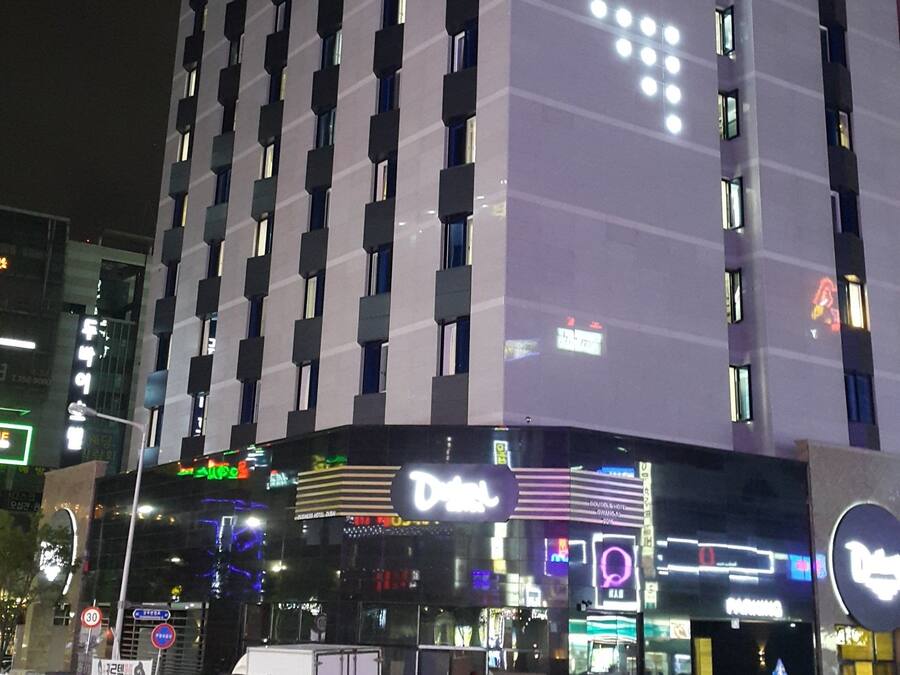 A multi-story hotel with a prominent sign for the "Duisai Hotel" and a visible "Duisai" sign on the ground floor.