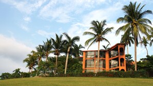 A building with a modern architectural style, surrounded by a well-maintained lawn and palm trees.