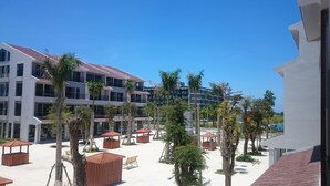 A hotel courtyard with multiple buildings, palm trees, and outdoor seating areas. - Kosmos Apart Hotel (Phu Quoc)