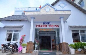 A hotel named "THANH TRUNG" with a traditional architectural style, featuring a tiled roof and a central entrance.