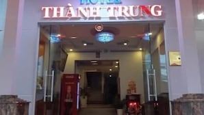 A hotel entrance with a glass facade, a red carpet, and a sign reading "HOTEL THANH TRUNG". - Thanh Trung Hotel (Phu Quoc)