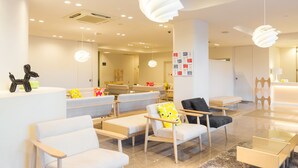 A modern hotel lobby with seating areas, a reception desk, and contemporary lighting fixtures. - Setouchiso (Sakaide)