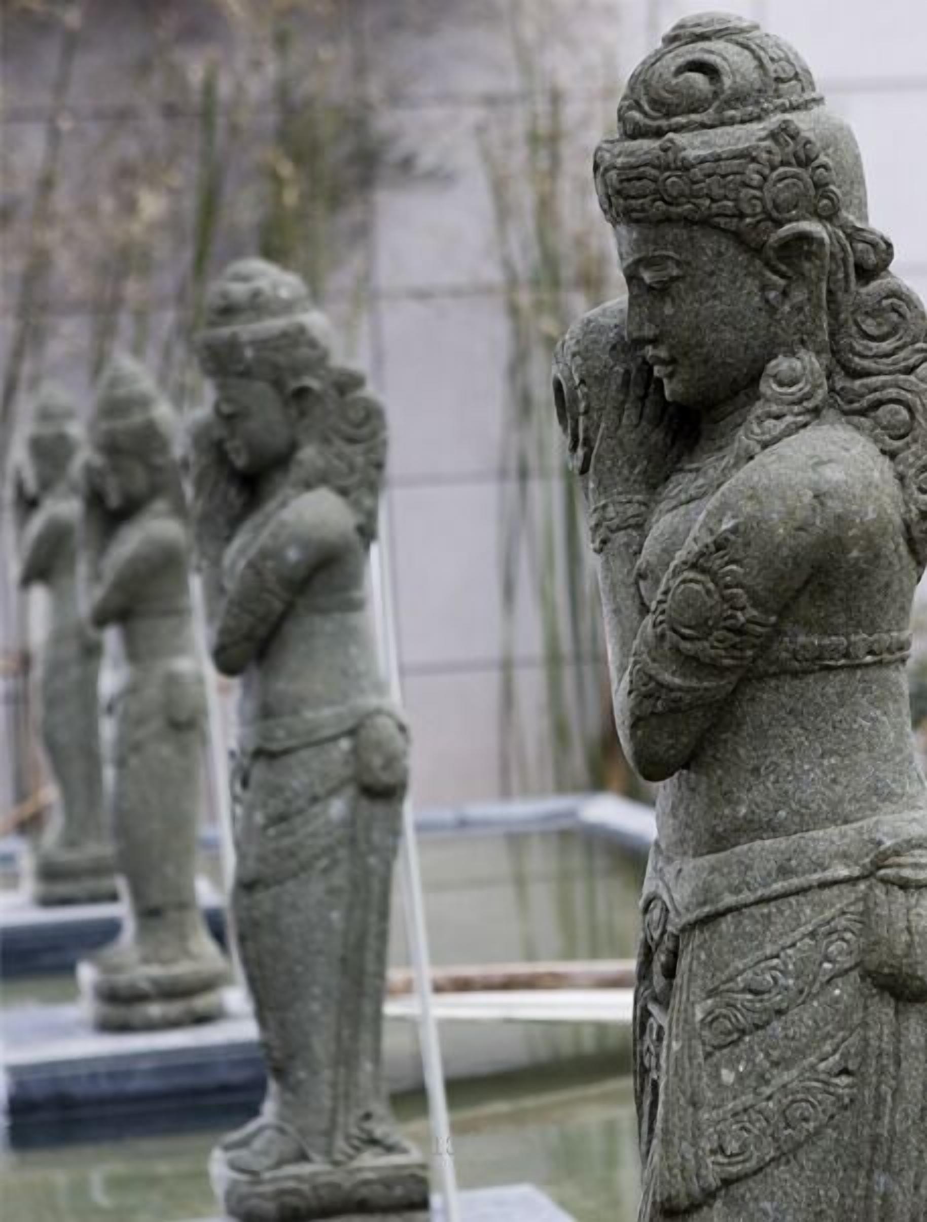 A row of stone statues in a museum setting.