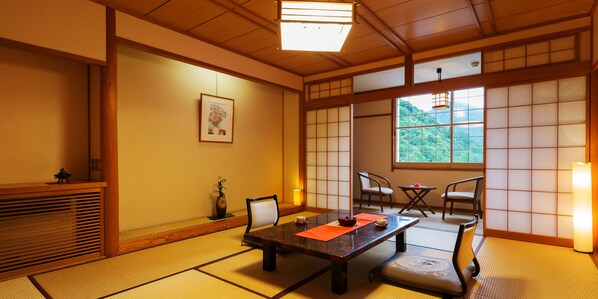 Une pièce de style japonais traditionnel, avec un sol recouvert de tatamis, une table basse et des portes coulissantes.