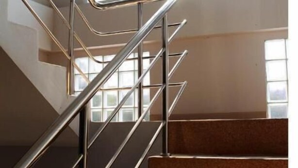 A staircase with metal railings and carpeted steps leading to a landing area. - Pornkasem House (Chiang Rai)