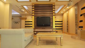 A modern living room with a flat-screen TV, a sofa, and a coffee table.