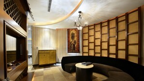 A modern living room with a curved sofa, a round coffee table, and a television. - OHYA Chain Boutique Motel-Yongkang (Tainan)