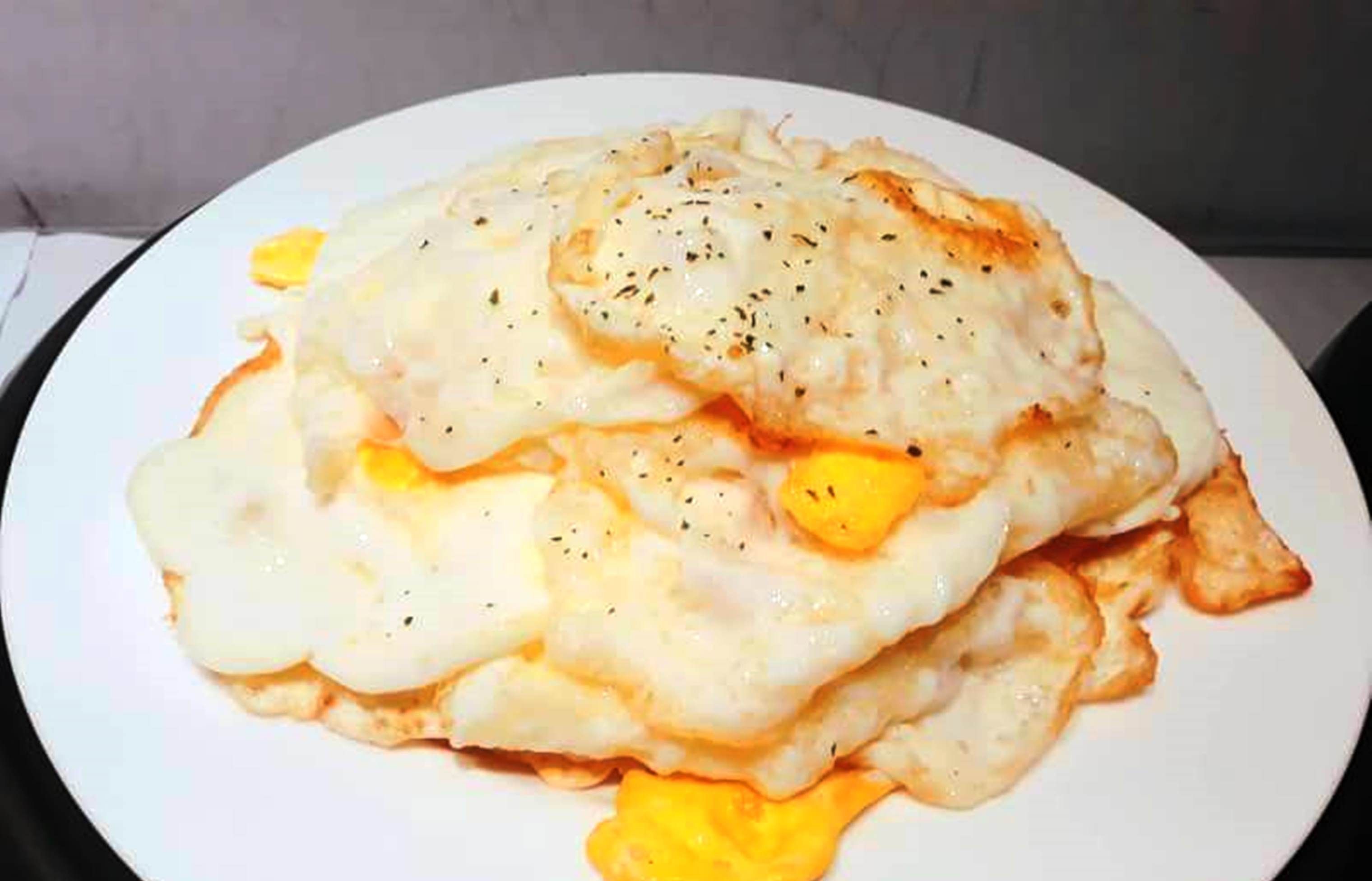 Un plato de huevos revueltos con queso y hierbas.