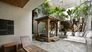 A patio with a wooden bench, a wooden gazebo, and a stone-tiled floor. - OHYA Chain Boutique Motel-Yongkang (Tainan)