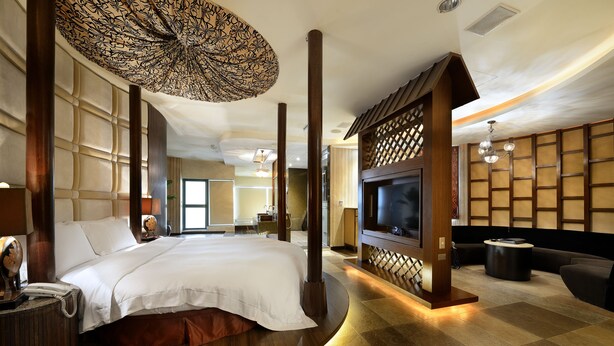 A spacious hotel room with a large bed, a TV, a sofa, and a decorative ceiling. - OHYA Chain Boutique Motel-Yongkang (Tainan)
