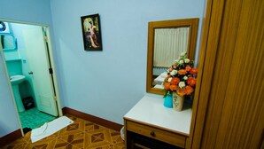 Ein Badezimmer mit Holzboden, einem weißen Waschbecken, einem Spiegel und einer Blumenvase.