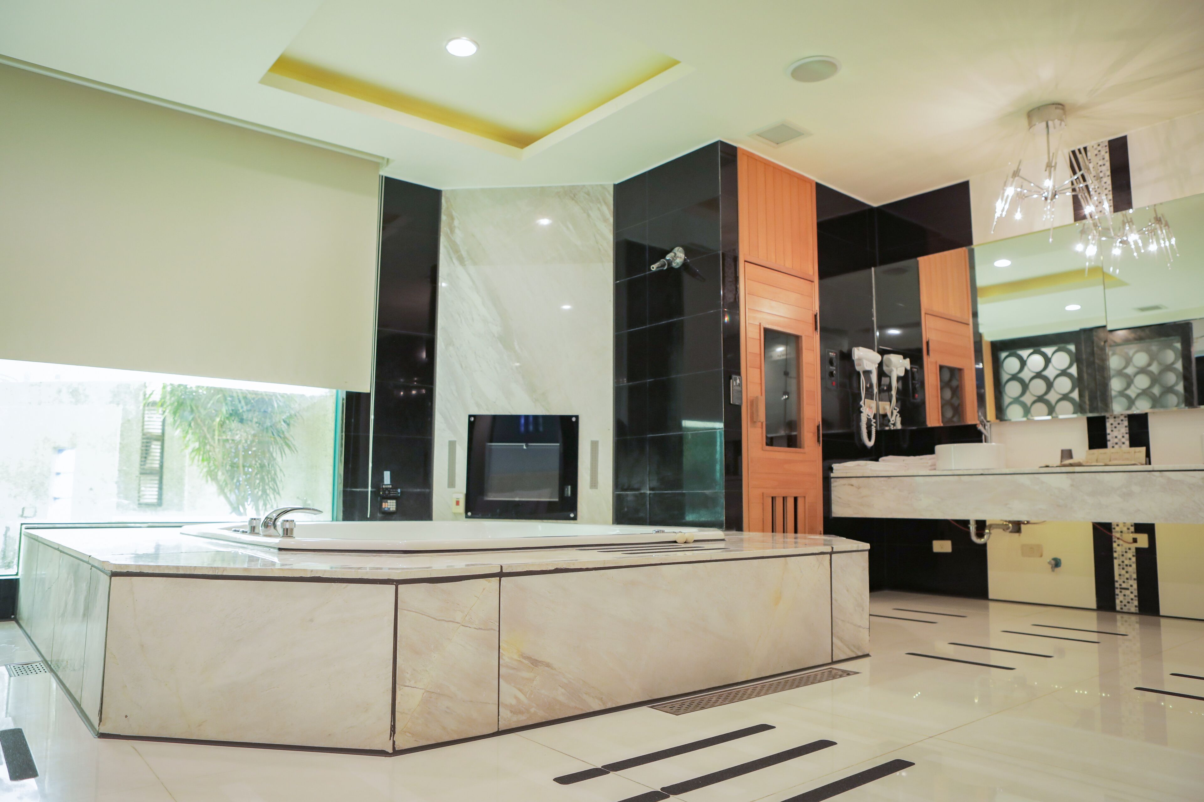 A modern bathroom with a large marble sink, a glass shower enclosure, and a wooden vanity.