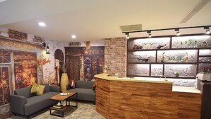 Eine gemütliche Lobby mit einer Rezeption, einer Couch und einem Couchtisch.