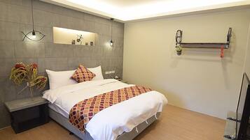 Een moderne hotelkamer met een groot bed, een nachtkastje, een wandplank en een vastgemaakte fiets.