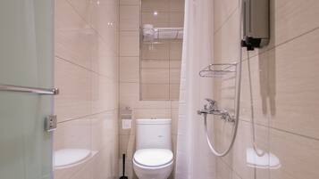 Une salle de bain moderne avec une douche à parois de verre, des toilettes et un pommeau de douche.