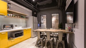 Uma cozinha moderna com armários amarelos, uma mesa de jantar de madeira e cadeiras de metal.