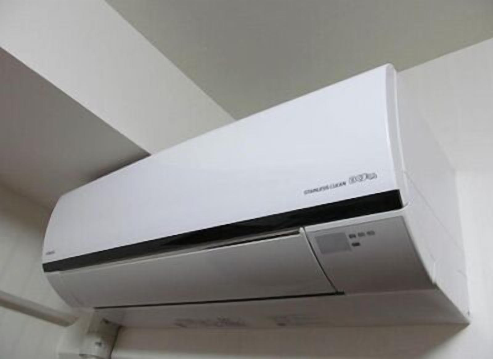 A white wall-mounted air conditioning unit with a control panel on the right side.