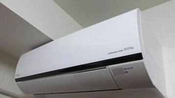A white wall-mounted air conditioning unit with a control panel on the right side.
