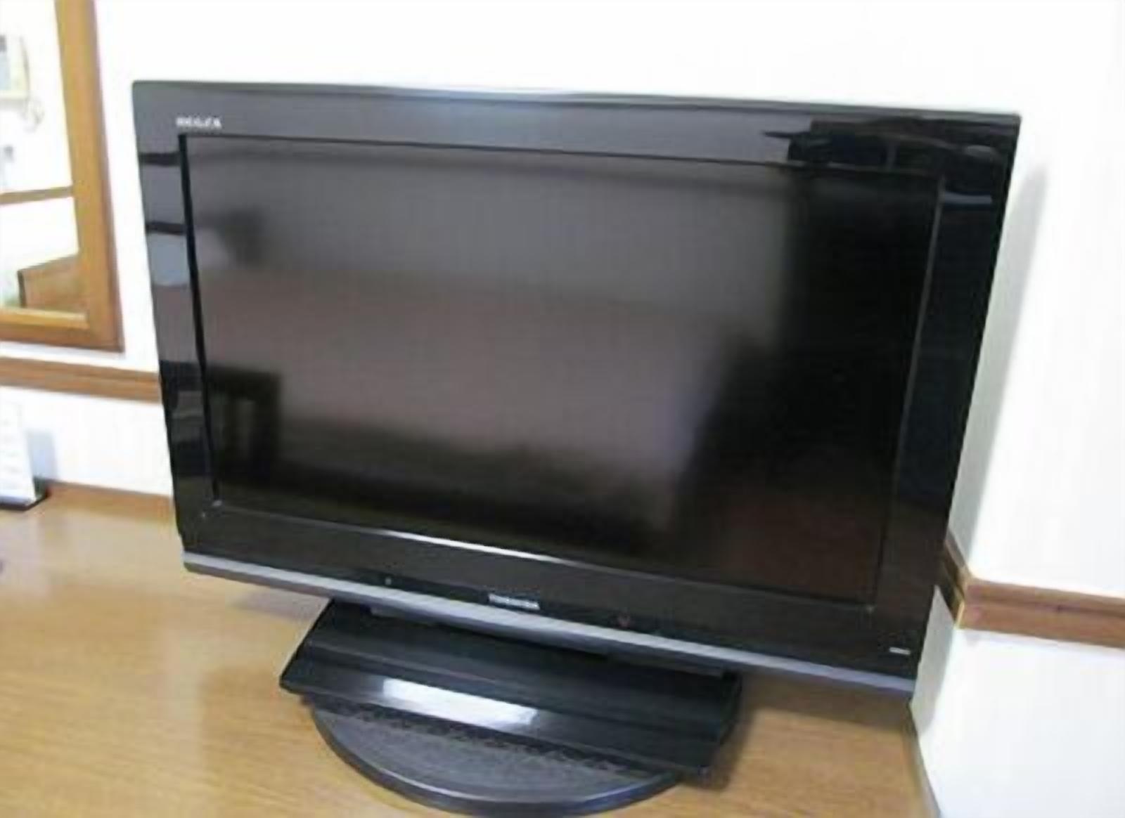 A flat-screen TV on a wooden stand.