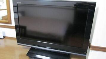 A flat-screen TV on a wooden stand.
