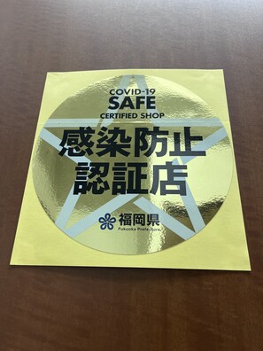 A COVID-19 safe shop certification sticker on a yellow surface. - City Inn Kokura (Kitakyushu)