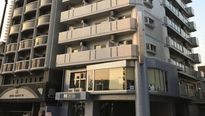 Un hotel de varios pisos con balcones, entrada a nivel de calle y un letrero visible de City Inn.