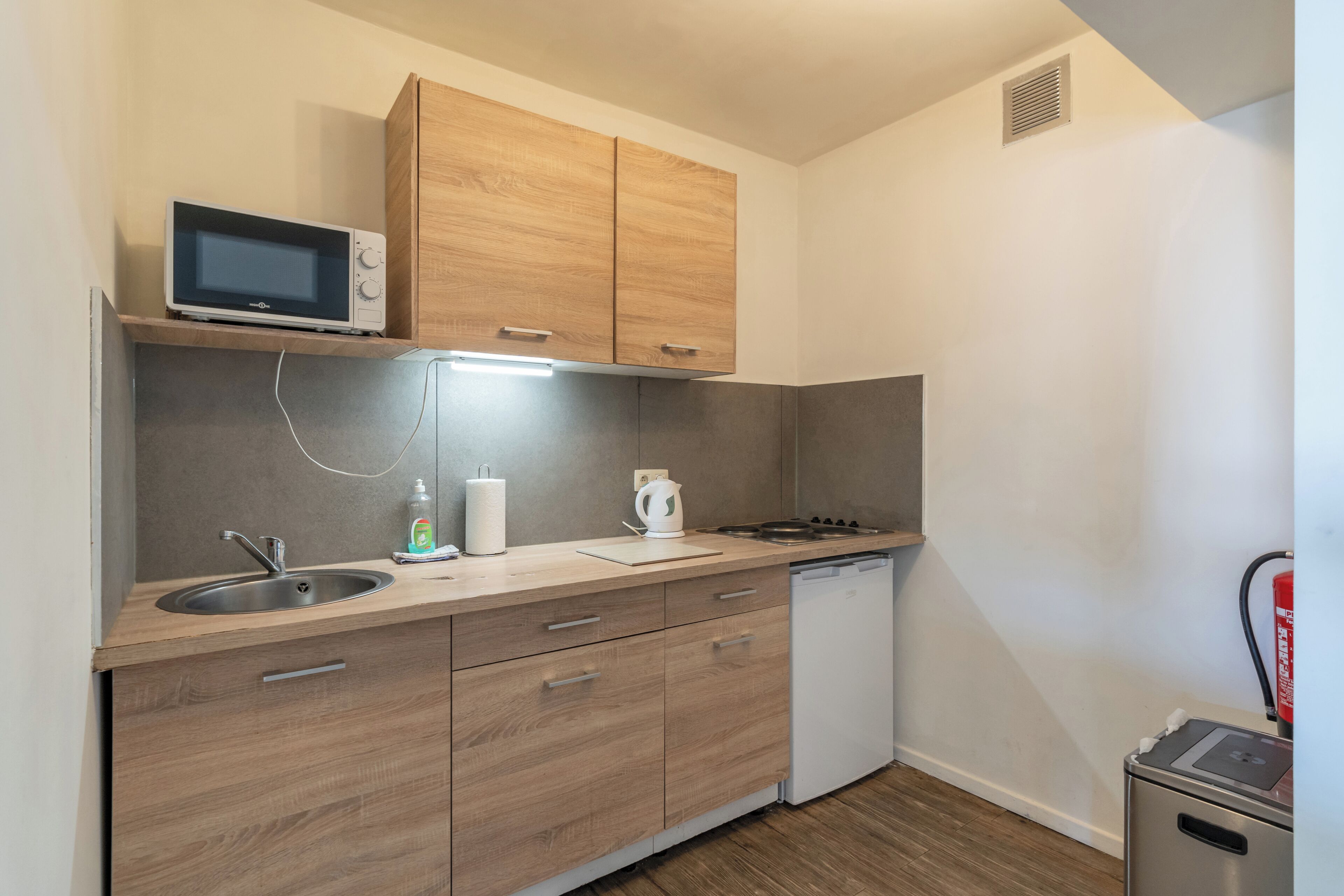 A compact kitchen with a microwave, sink, stove, and dishwasher.
