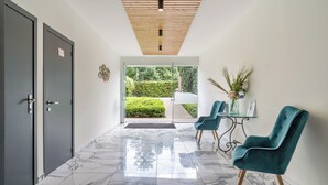 A modern lobby with marble flooring, a wooden ceiling, and a glass door leading outside. - Value Stay Residence Mechelen (Mechelen)