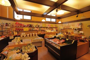 Un magasin bien éclairé, avec différents produits emballés exposés sur des étagères et des comptoirs.