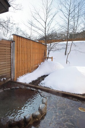 A stone pathway leading to a wooden fence with snow accumulation. - Wan Wan Paradise Takayama (Takayama)
