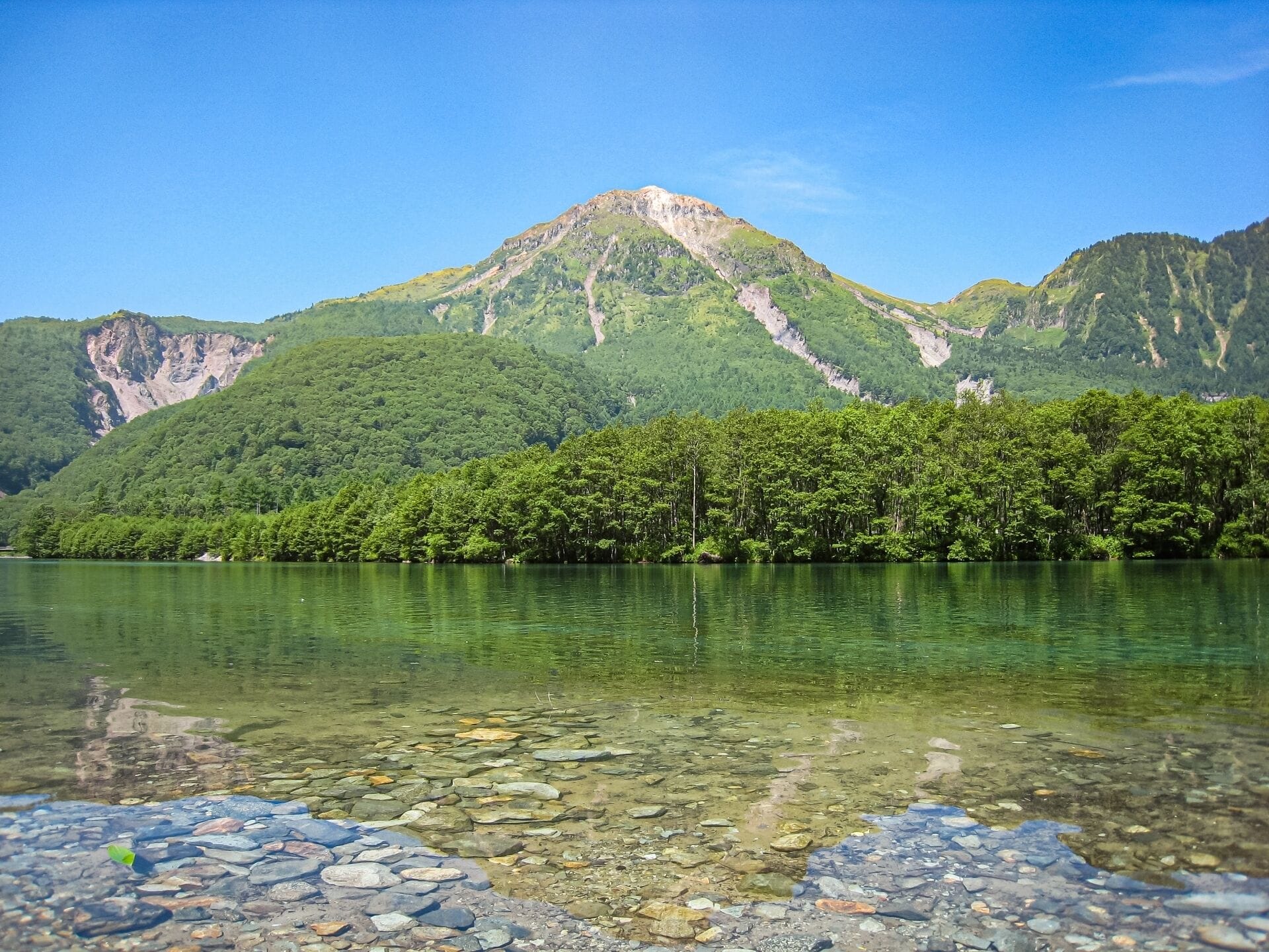 A mountain landscape with a clear lake in the foreground.