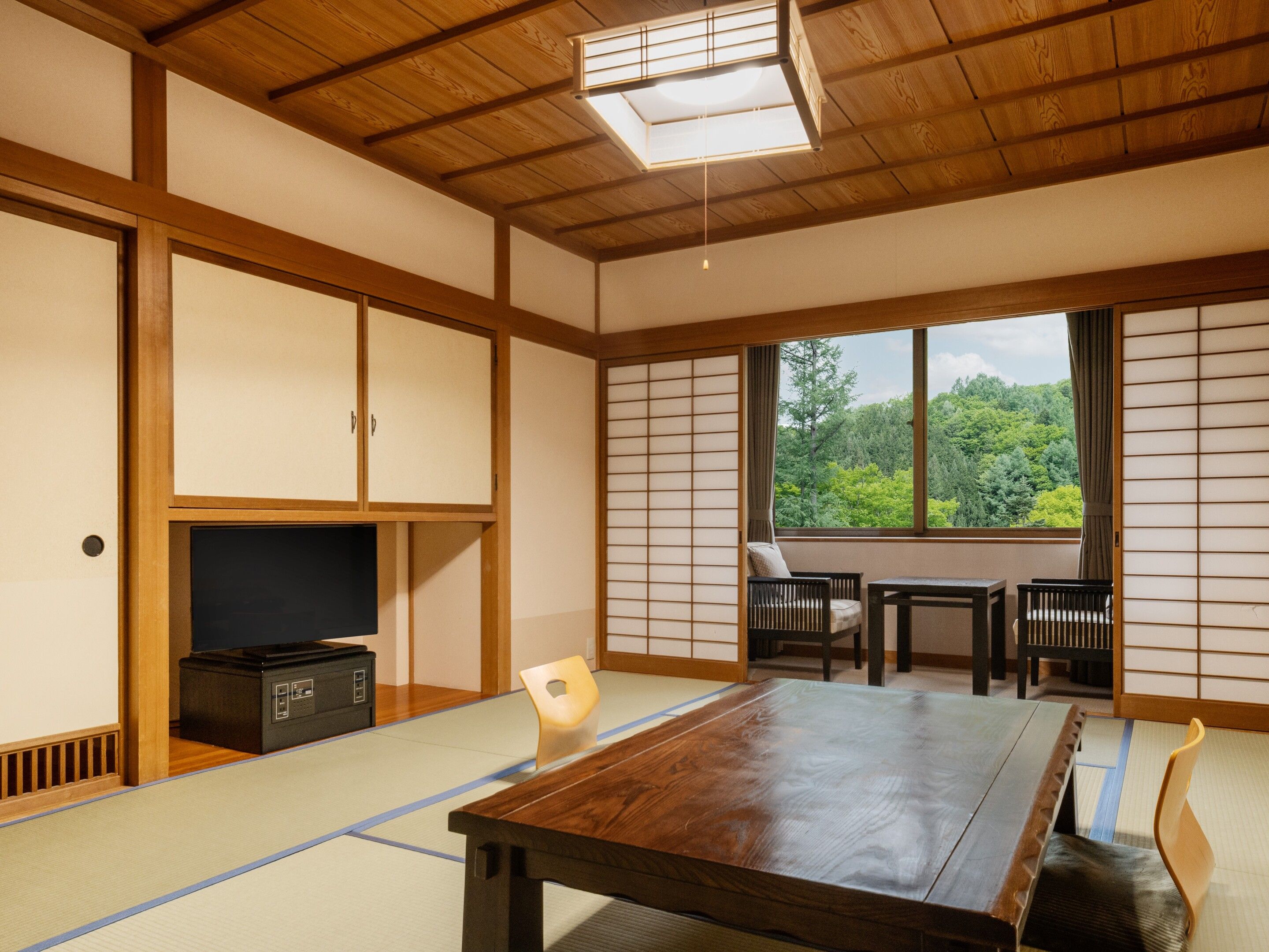 A traditional Japanese room with tatami flooring, a low table, and sliding doors.